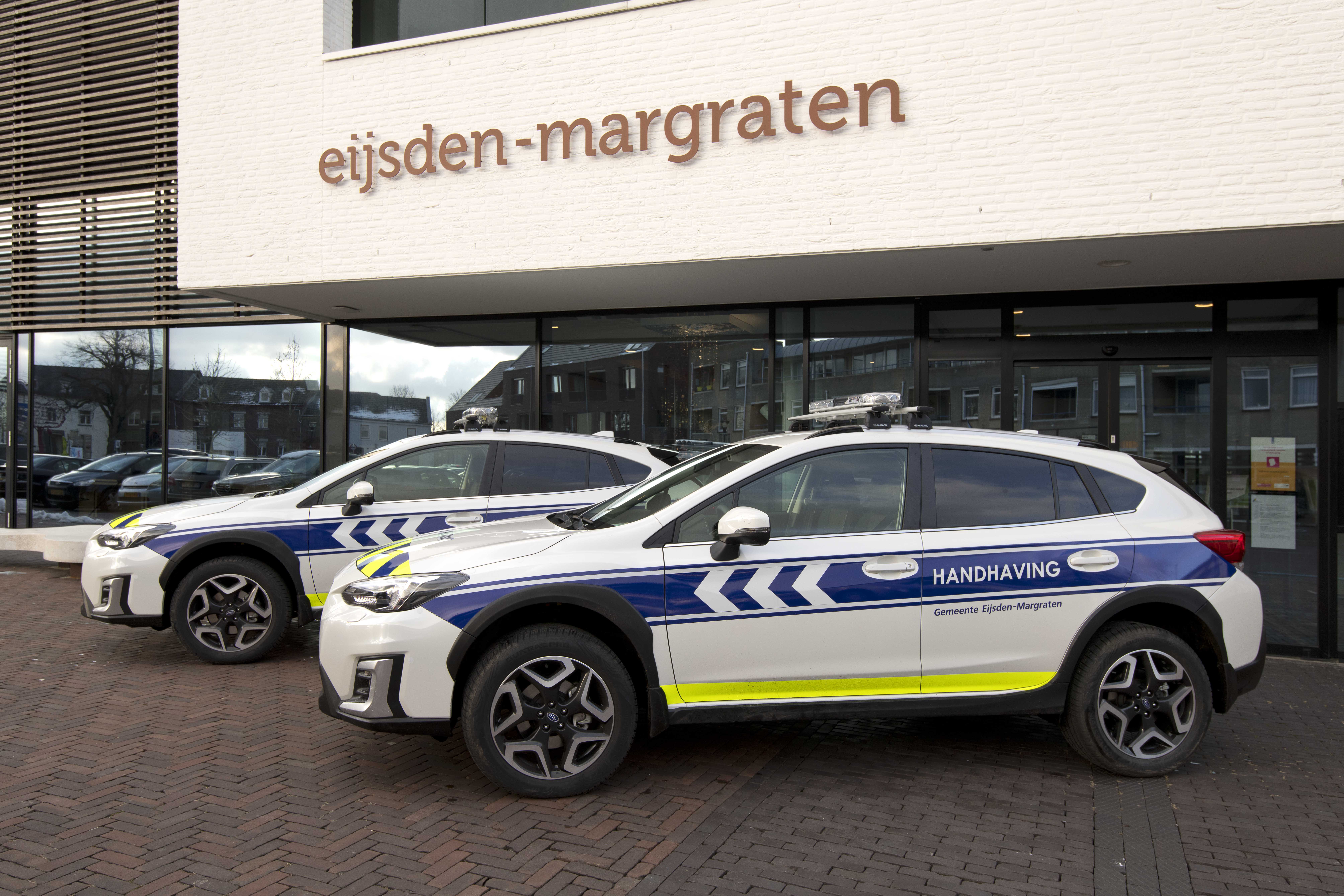 2 auto's van handhaving voor het gemeentehuis in Margraten. 